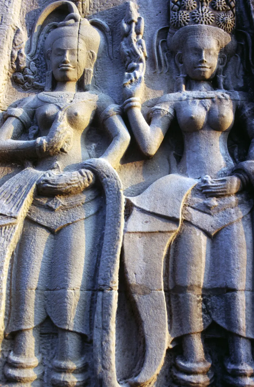 Beautiful carving of two dancing women on the temple walls of Angkor Wat, the most majestic of the many temples in the ancient city of Angkor, Cambodia. This temple was built by the rulers of the Khmer people over eight centuries ago as a dedication to the Hindu god Vishnu.
