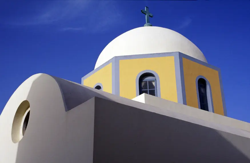 A yellow, white, and blue church in Ia, a town in the Greek Cyclades island of Santorini.