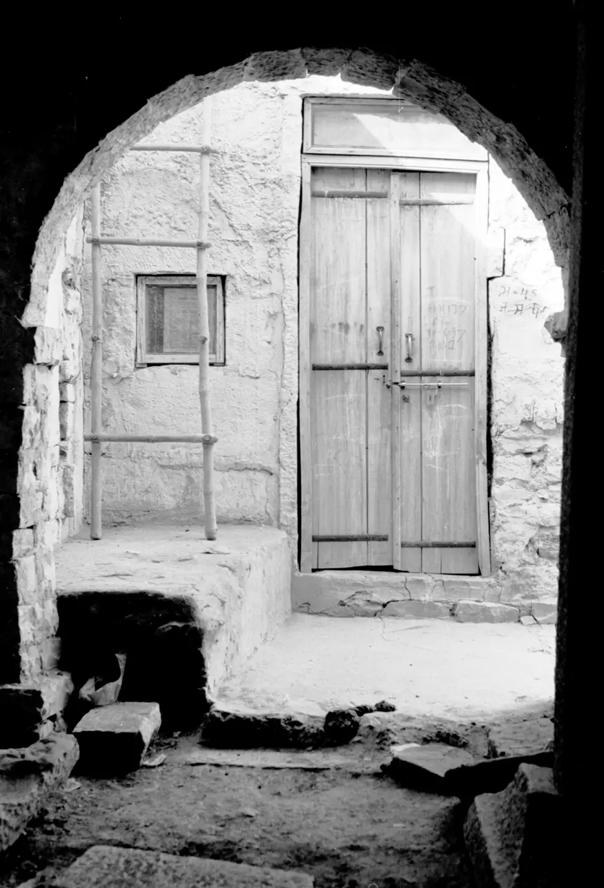 An arch in the old section of Rajasthan's Jaisalmer frames a doorway from across the alley.