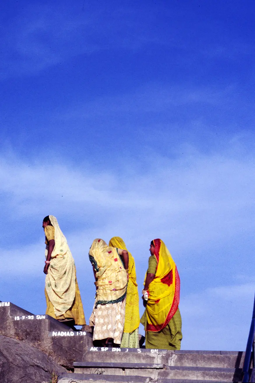 Women in colorful saris climb the 365 stairs up to the top of the Hindu Adhar Devi temple near Mt. Abu.