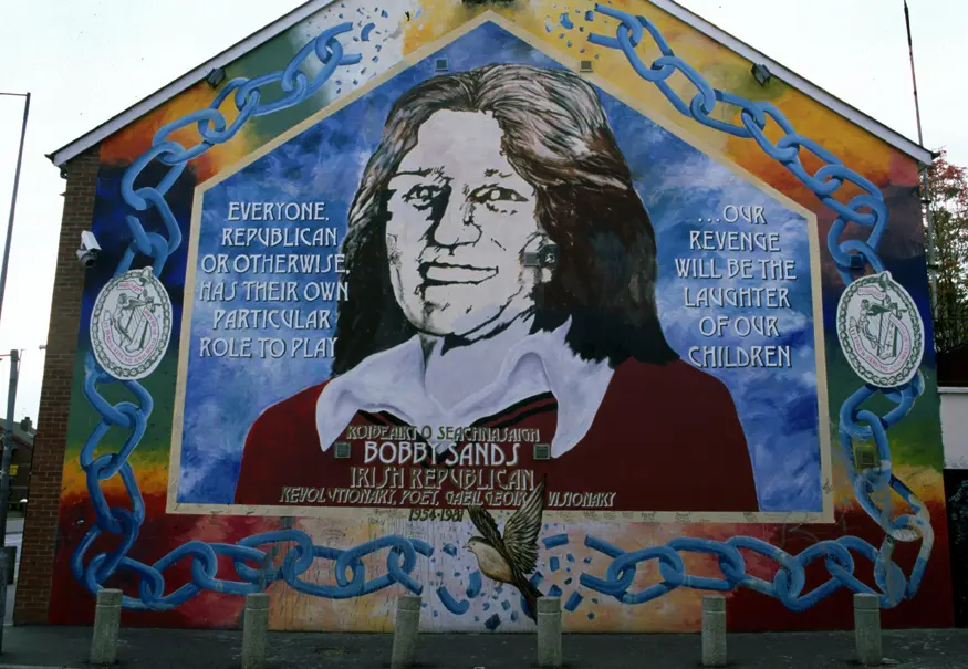 Mural on Sinn Fein headquarters depicting Bobby Sands, the IRA leader of the 1981 hunger strike in Maze Prison. Located in the Falls Road (Republican area) of Belfast.
Inscription reads, ""Everyone, Republican or otherwise, has their own particular role to play ...our revenge will be the laughter of our children.""