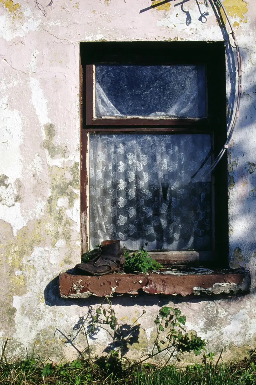 An old shoe sits in the window of a traditional grass roofed house on the west coast of Ireland.