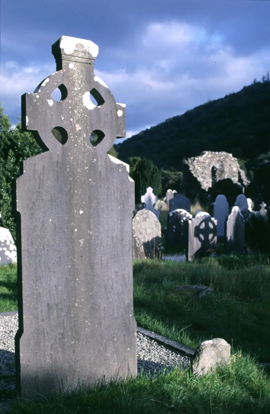 A Celtic cross headstone in a graveyard near the Glendalough Monastery. The monastery was founded during the sixth century and remained active until the sixteenth century.