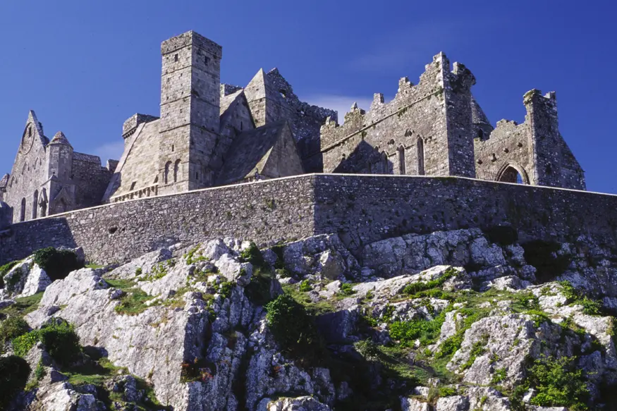 The stone wall and historic gothic structures of the Rock of Cashel.