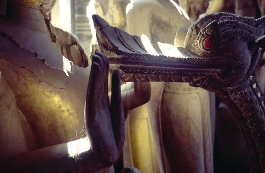 Damaged wooden carved Buddhas and other statues lie stacked in the back of Luang Prabang's Wat Xieg Thong, Laos.