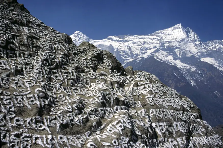 Prayer stones carved along paths in Nepal are thought to release blessings of compassion to those who walk by.