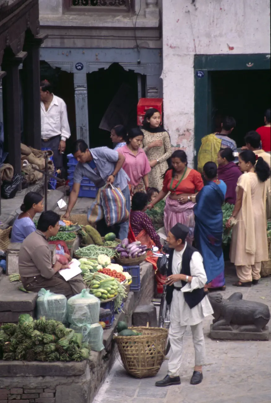 People gather to talk and buy vegetables from a market in Kathmandu's Durbar Square.
