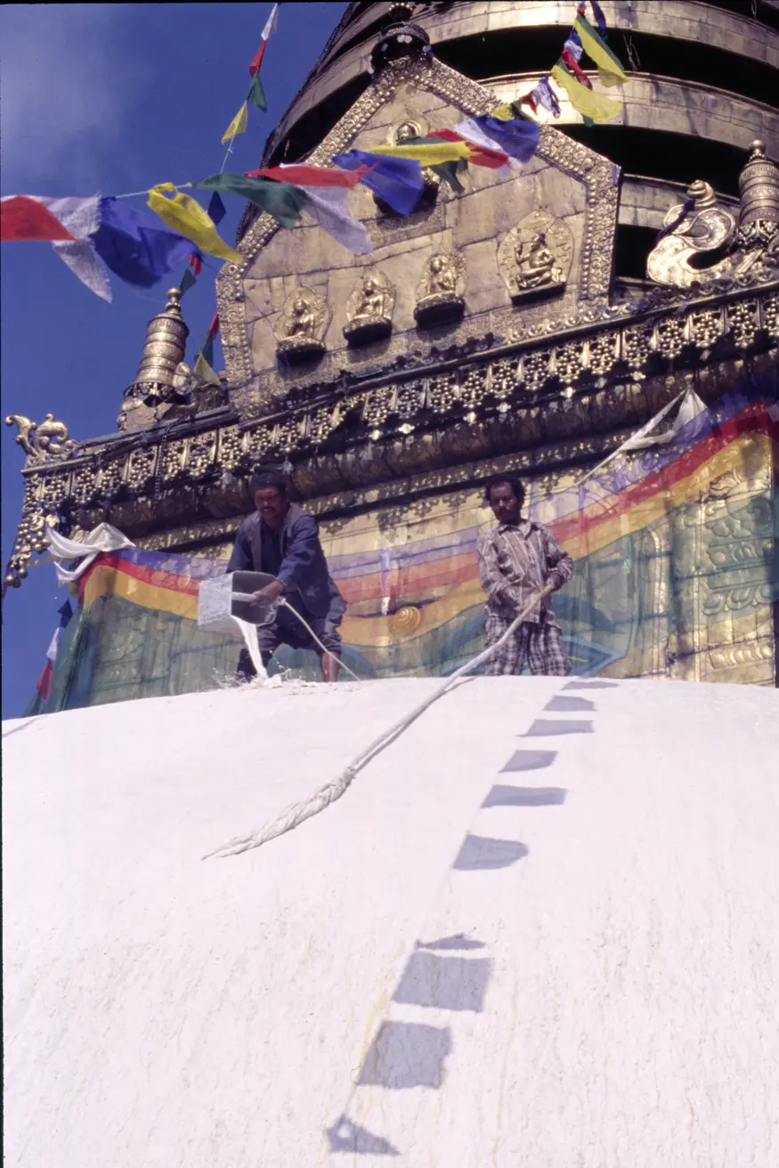 Two men try to keep the stupa at Kathmandu's Monkey Temple (Swayambhunath) brightly whitewashed during an important Buddhist celebration.