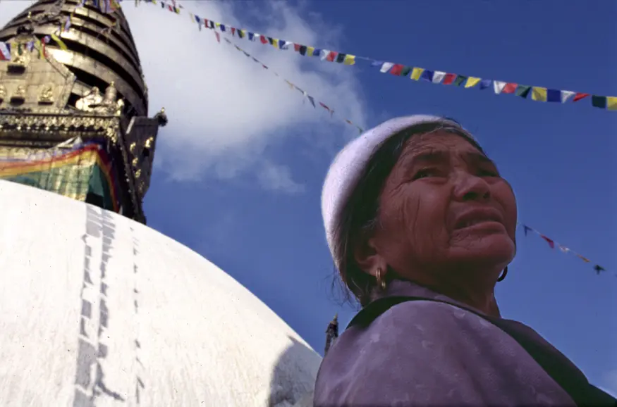 A woman stands next to Kathmandu's Monkey Temple (Swayambhunath) during Buddha Jayanti, the celebration of Buddha's birthday 2545 years ago.