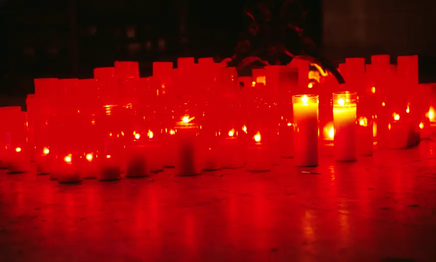 Red church candles offer prayers in a San Sebastian Catholic church.
