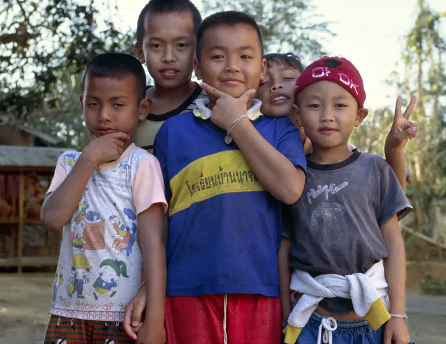 Five Thai kids flash big smiles and try to impress us with their phrases of broken English, ""Hello, how are you, I am fine...""