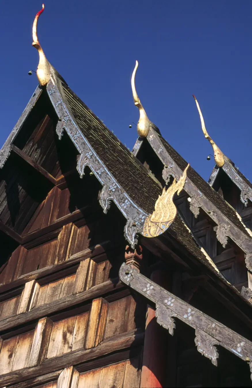 The sloping wooden roof of Wat Phan Tao in Chiang Mai, Thailand is a prime example of the northern Thai ""Lanna style"" temple architecture.