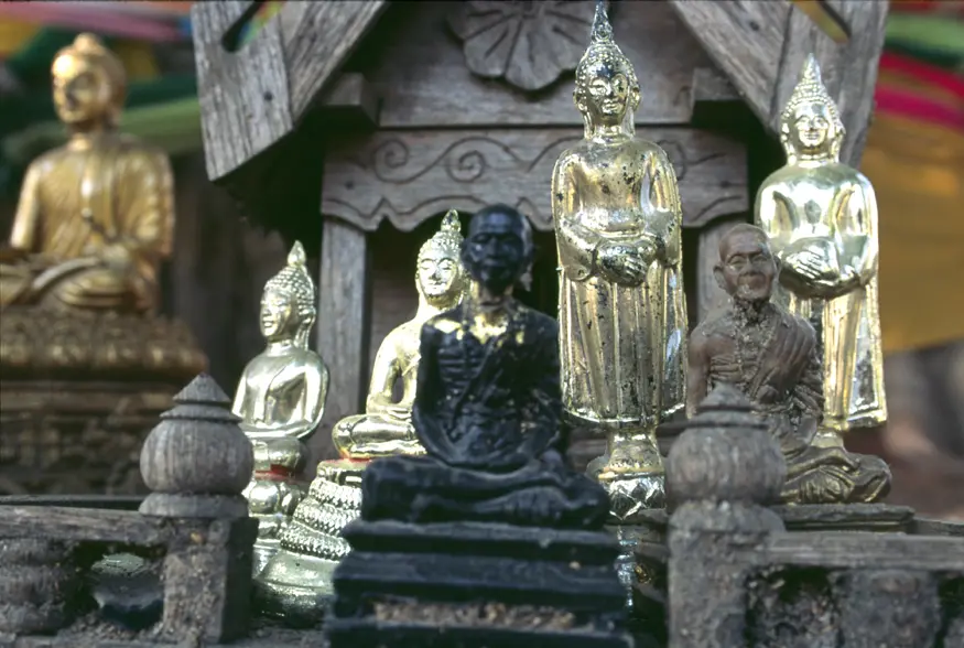 Statuettes of revered monks and Buddha adorn the Suan Dawk temple in Chiang Mai, Thailand.