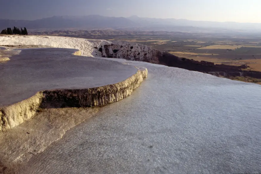 A travertine pool in Pamukkale, Turkey, formed by years of calcium deposits by the area's mineral-rich waters. The ancient Roman spa city of Hierapolis rests nearby this area, making Pamukkale important enough for UNESCO to declare it a World Heritage Site.